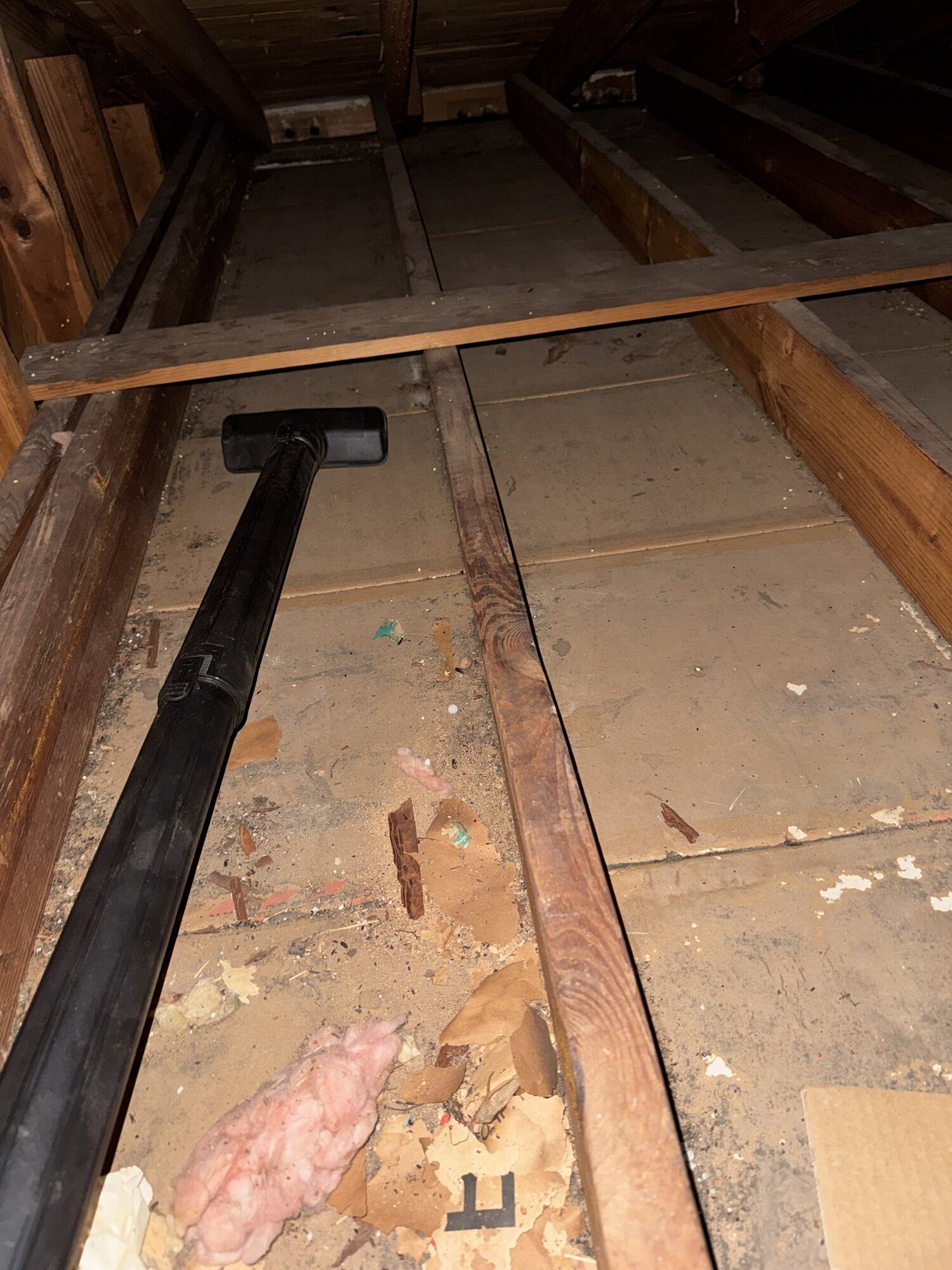 Shop vac cleanup of wall cavity during attic insulation removal
